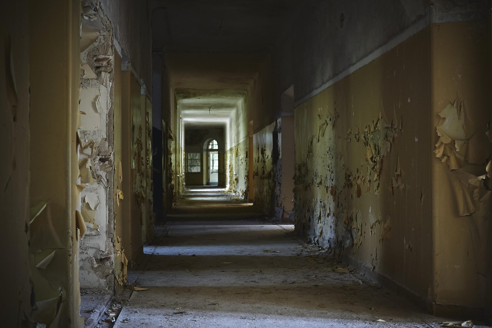 The hallway of an abandoned building with aged walls under the lights - cool for grunge backgrounds